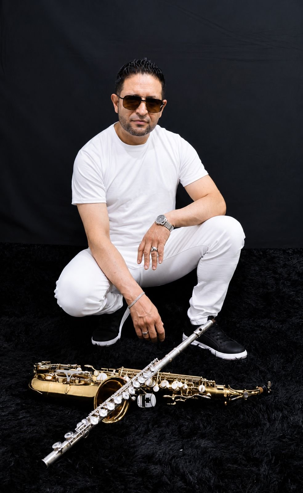 Saxofonista de Bogotá sentado junto a su saxofón alto dorado y su flauta traversa